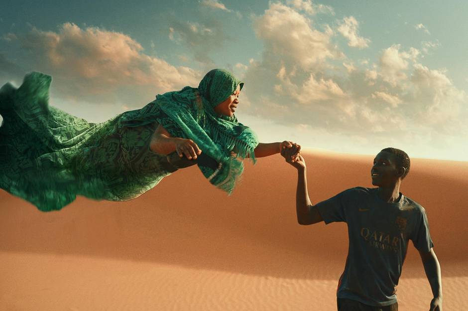 Lady reaching out to man in desert